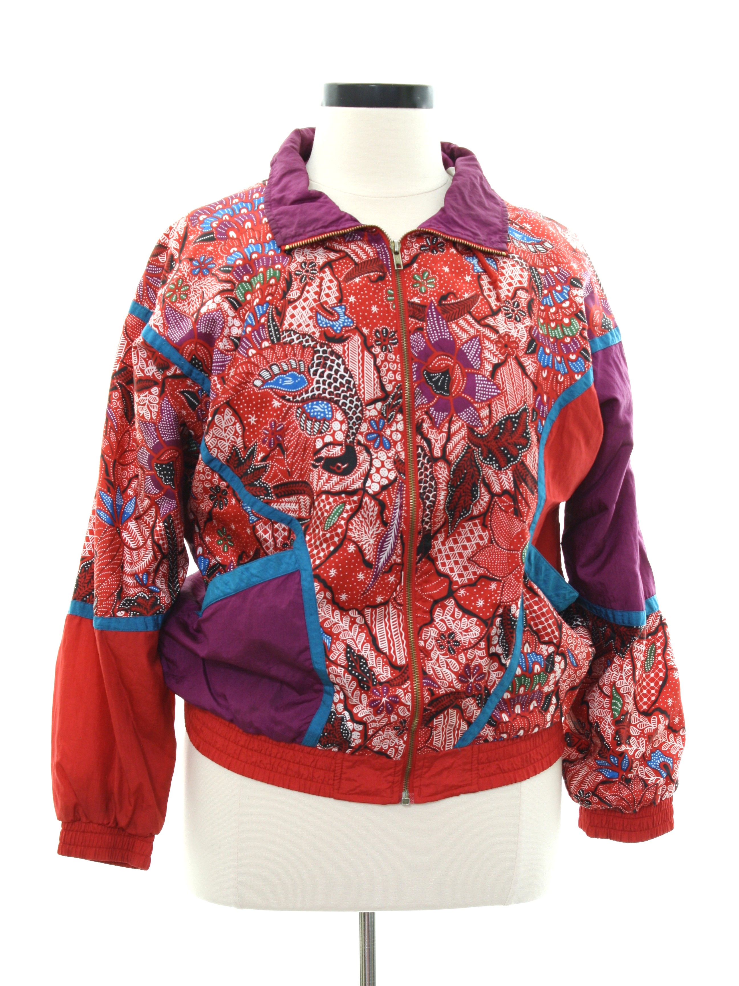 Jacket made in 90s Bold Spirit Womens multi color background nylon and polyester blend elastic cuff longsleeve zip front jacket. Color blocked solids and batik style prints in shades of red plum