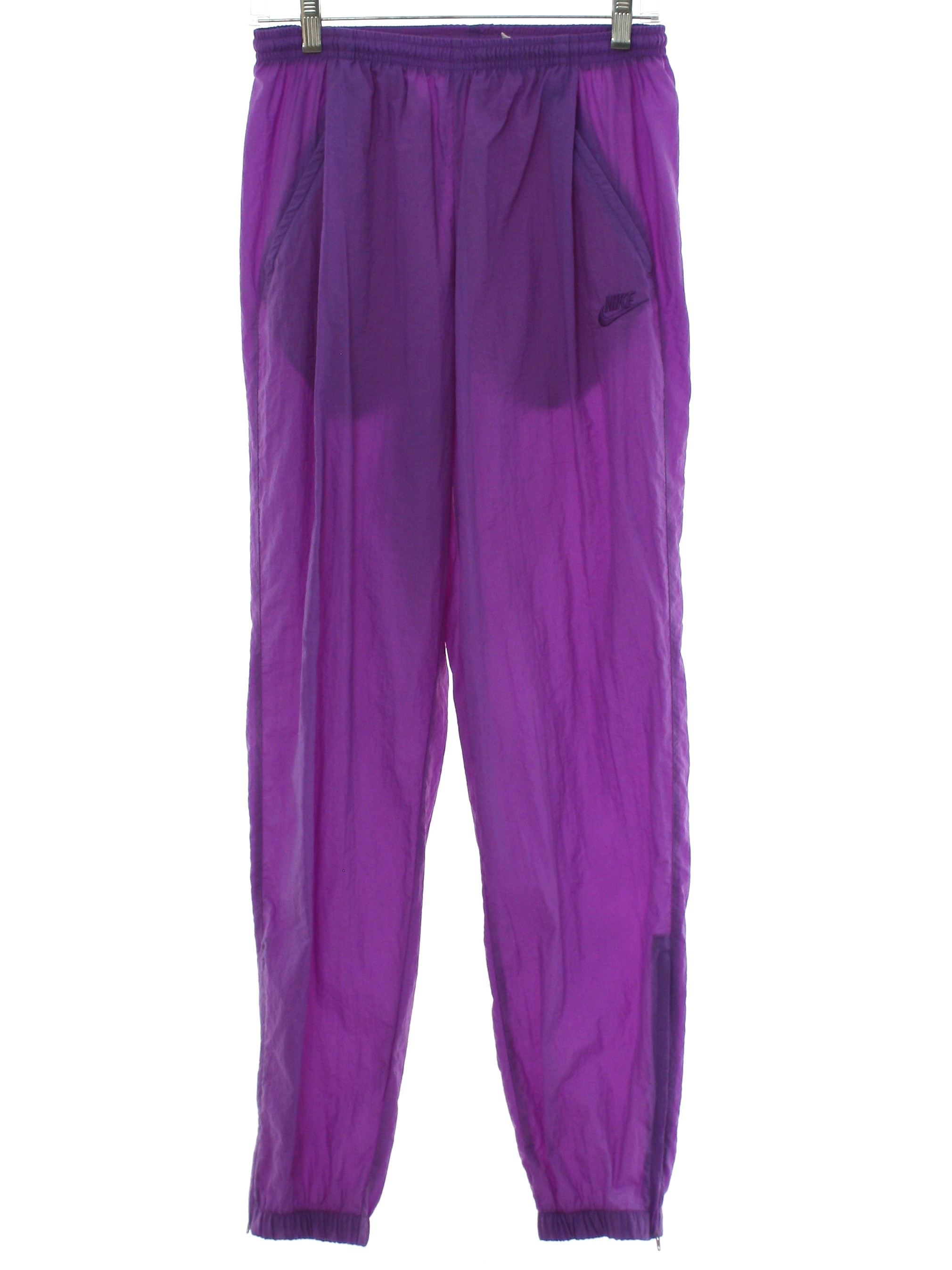 Vintage Nike 80's Pants: 90s -Nike- Womens purple nylon track pants.  Elastic pull on waistband with inside front drawstring ties, angled front  zip pockets, zippered elastic leg cuffs. Nike logo on the